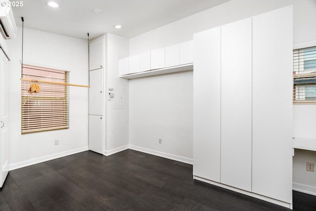 interior space with an AC wall unit and dark hardwood / wood-style floors