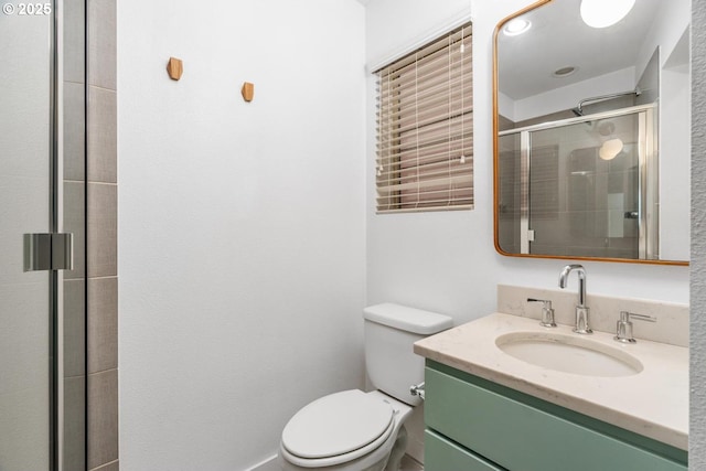 bathroom with toilet, a shower with door, and vanity