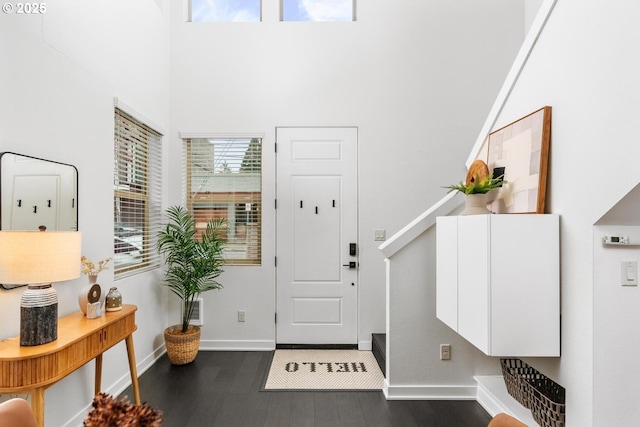 entrance foyer with dark hardwood / wood-style flooring and a towering ceiling