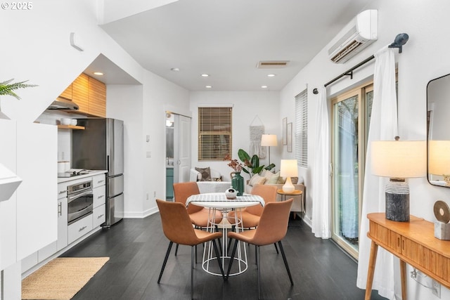 dining area featuring a wall mounted air conditioner and dark hardwood / wood-style floors