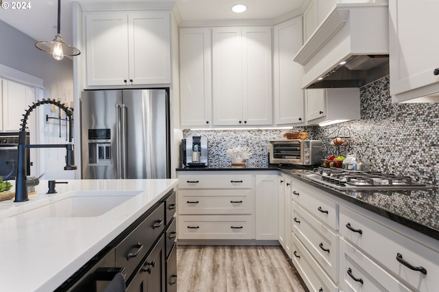 kitchen featuring appliances with stainless steel finishes, white cabinetry, and custom exhaust hood