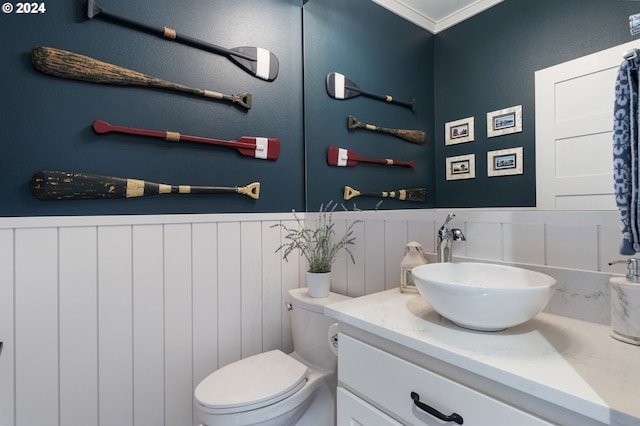 bathroom featuring crown molding, vanity, and toilet