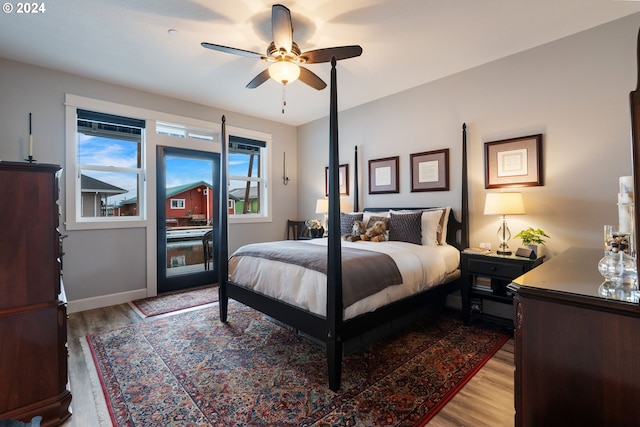 bedroom with ceiling fan, light wood-type flooring, and multiple windows