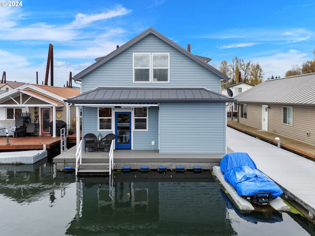 rear view of house featuring a deck with water view