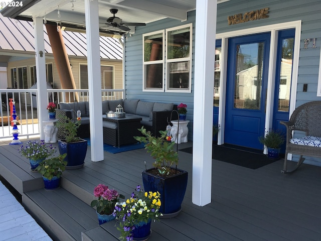 wooden deck with outdoor lounge area, a porch, and ceiling fan