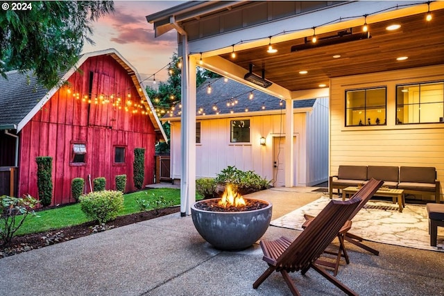 patio terrace at dusk featuring an outdoor living space with a fire pit