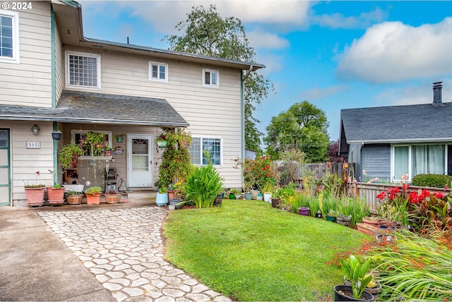 rear view of property featuring a patio area and a lawn