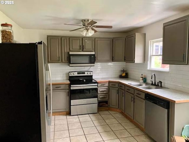 kitchen featuring backsplash, sink, ceiling fan, light tile patterned flooring, and stainless steel appliances