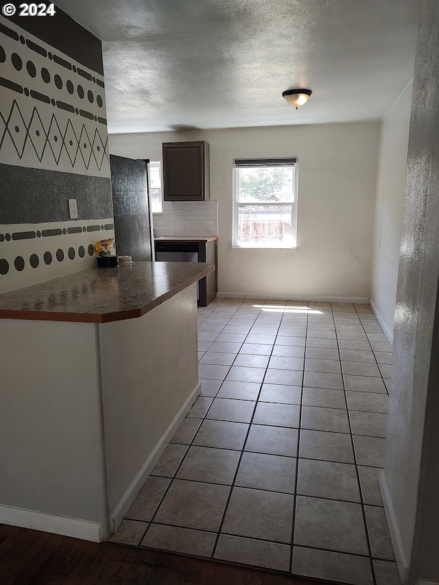 kitchen with decorative backsplash, light tile patterned floors, and a fireplace