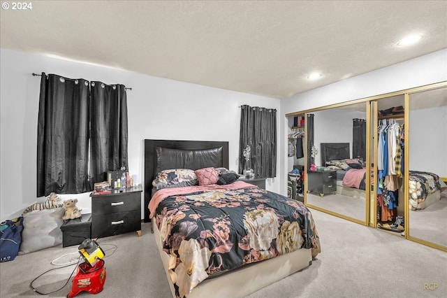 carpeted bedroom with a closet and a textured ceiling