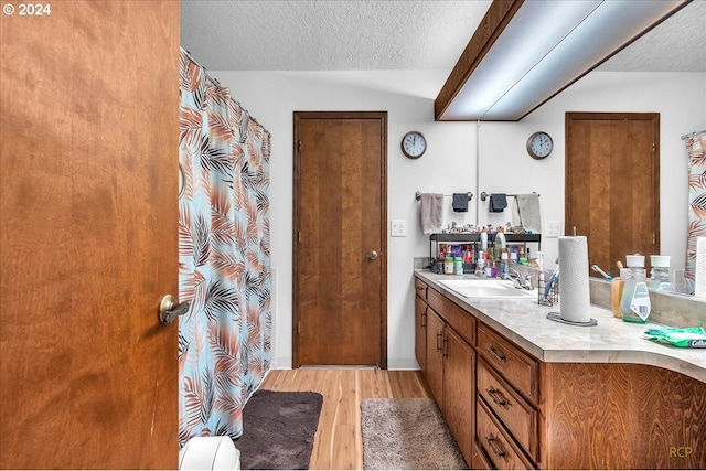 bathroom featuring vanity, hardwood / wood-style flooring, and a textured ceiling