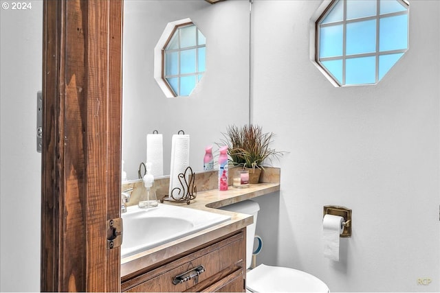 bathroom with a wealth of natural light, vanity, and toilet