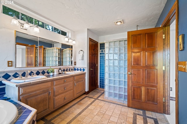 bathroom featuring a sink, walk in shower, wainscoting, and double vanity