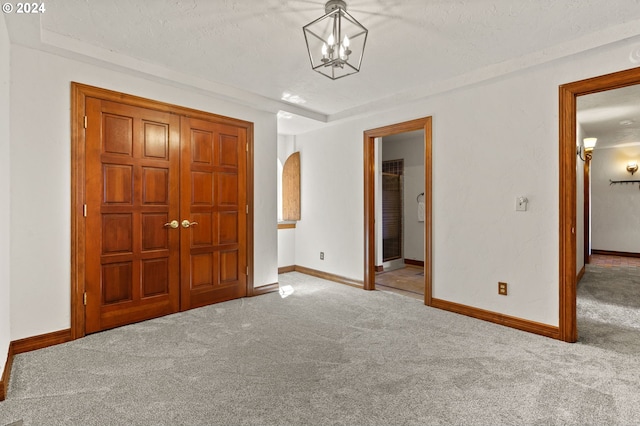 unfurnished bedroom featuring carpet flooring, baseboards, arched walkways, and a textured ceiling