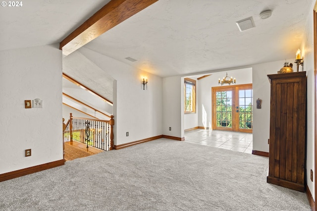 empty room featuring visible vents, baseboards, a chandelier, lofted ceiling with beams, and carpet flooring