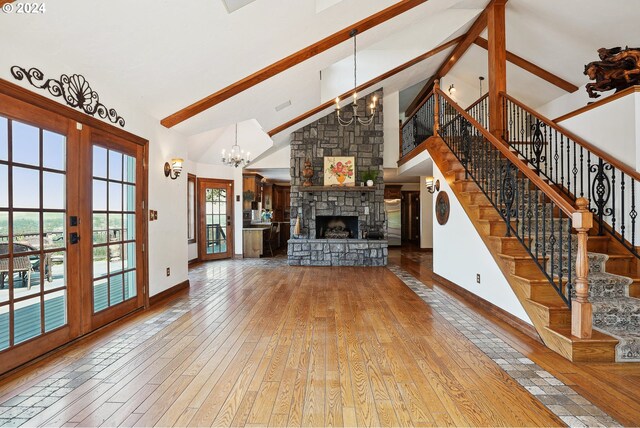 unfurnished living room featuring stairway, wood finished floors, beamed ceiling, and a chandelier