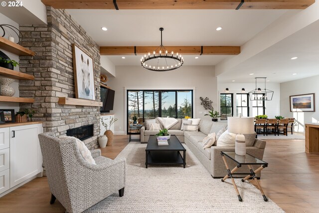 living room featuring a fireplace, light hardwood / wood-style flooring, beamed ceiling, and a notable chandelier