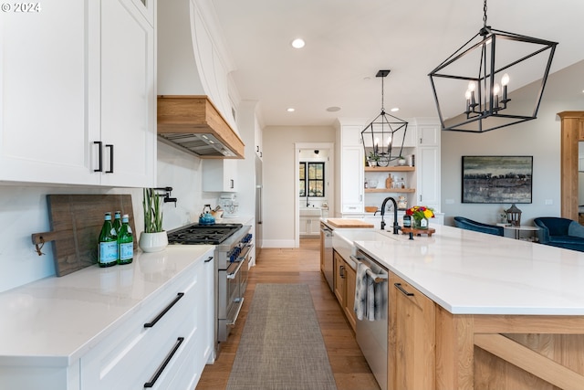 kitchen featuring a spacious island, white cabinetry, stainless steel appliances, and light wood-type flooring