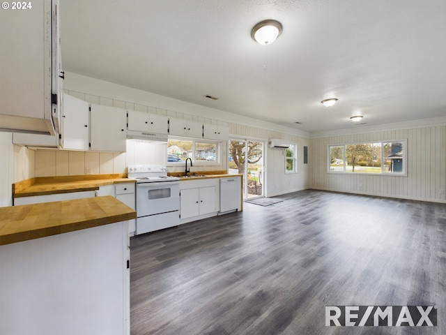 kitchen with wooden counters, white appliances, a wall unit AC, sink, and white cabinetry