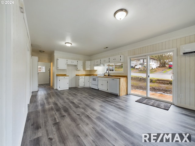 kitchen featuring white cabinets, a healthy amount of sunlight, white appliances, and a wall mounted AC