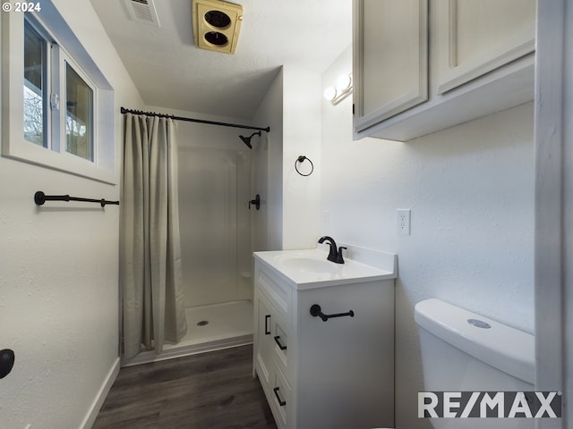 bathroom featuring hardwood / wood-style floors, vanity, curtained shower, and toilet