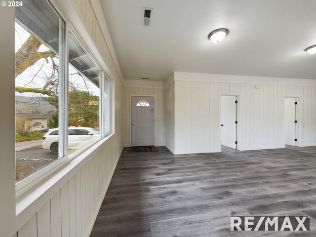 entrance foyer with dark hardwood / wood-style floors and wood walls