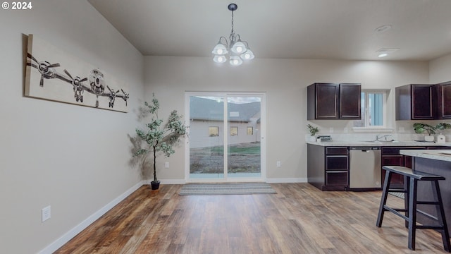 kitchen featuring dark brown cabinetry, wood-type flooring, decorative light fixtures, and dishwasher