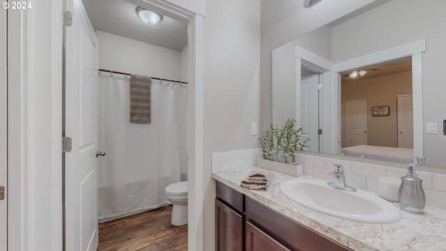 full bathroom with toilet, vanity, hardwood / wood-style flooring, and shower / bath combo with shower curtain