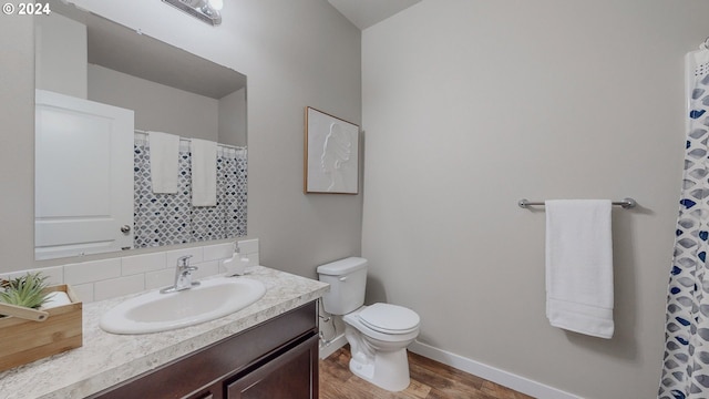 bathroom featuring wood-type flooring, vanity, toilet, and decorative backsplash