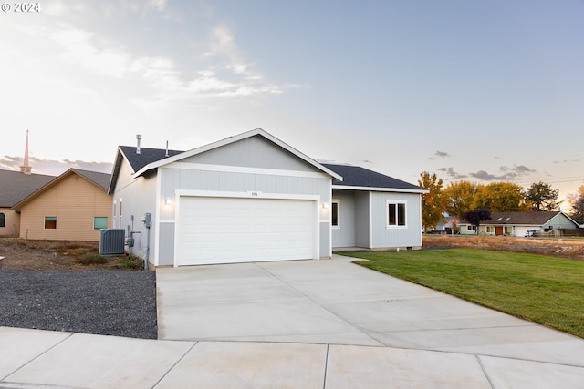 ranch-style house featuring central AC, a garage, and a lawn