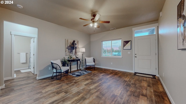 living area with dark wood-type flooring and ceiling fan