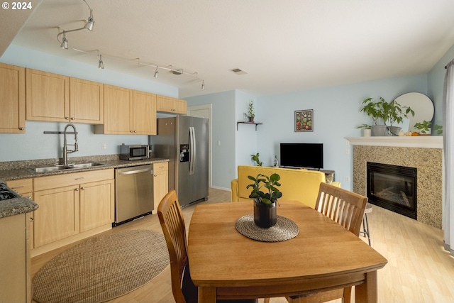 kitchen with light wood-type flooring, sink, stainless steel appliances, and light brown cabinets