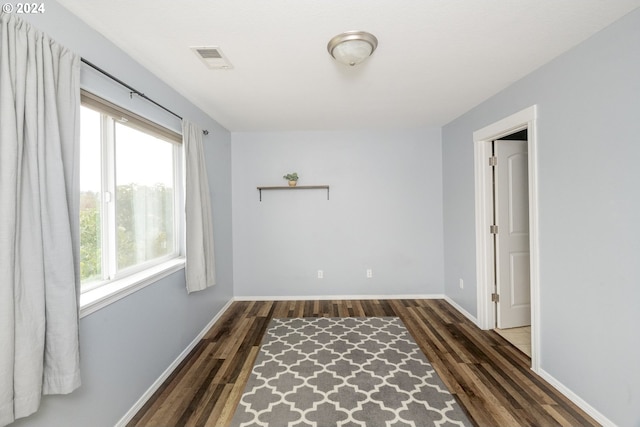 unfurnished bedroom featuring dark hardwood / wood-style flooring and multiple windows