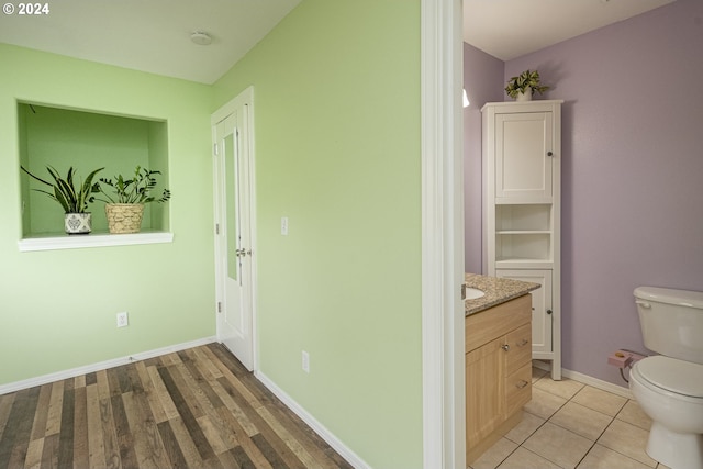 bathroom featuring wood-type flooring, vanity, and toilet