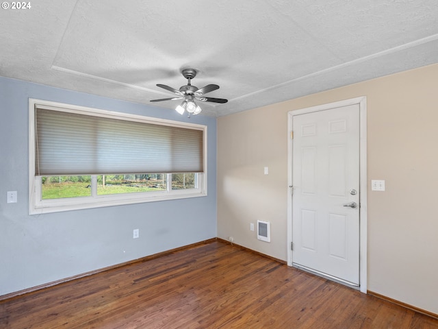 unfurnished room featuring a textured ceiling, dark hardwood / wood-style flooring, and ceiling fan