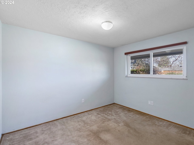 carpeted empty room with a textured ceiling