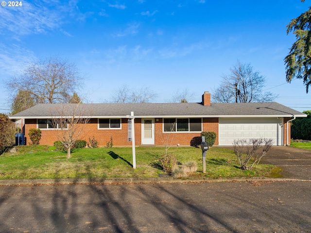 ranch-style house featuring a front yard and a garage