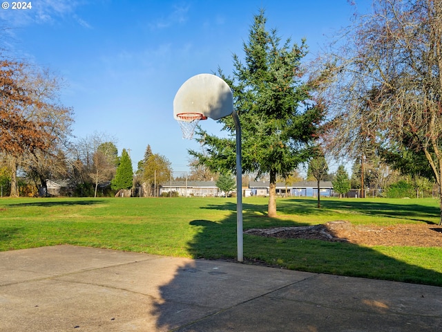 view of sport court with a lawn