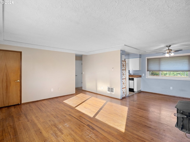 unfurnished living room featuring ceiling fan, hardwood / wood-style floors, and a textured ceiling