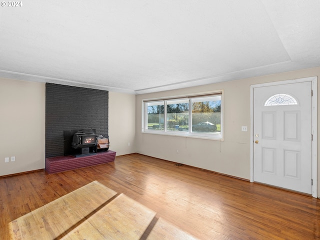 foyer with hardwood / wood-style floors and a wood stove