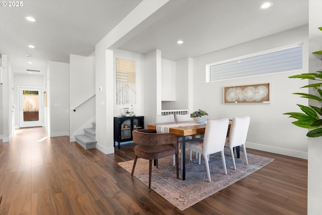 kitchen with white cabinetry, decorative light fixtures, a center island with sink, a large fireplace, and decorative backsplash