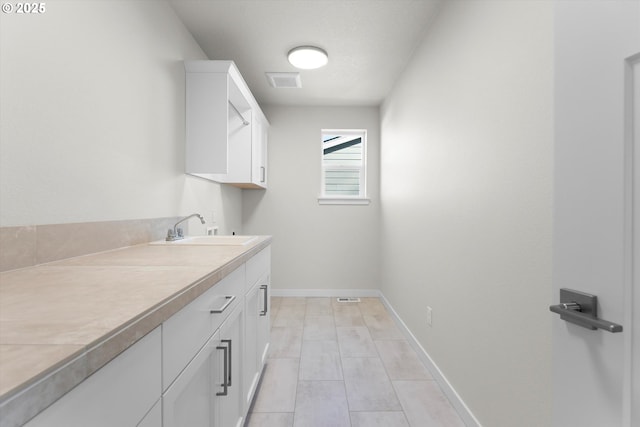 laundry area with sink and cabinets