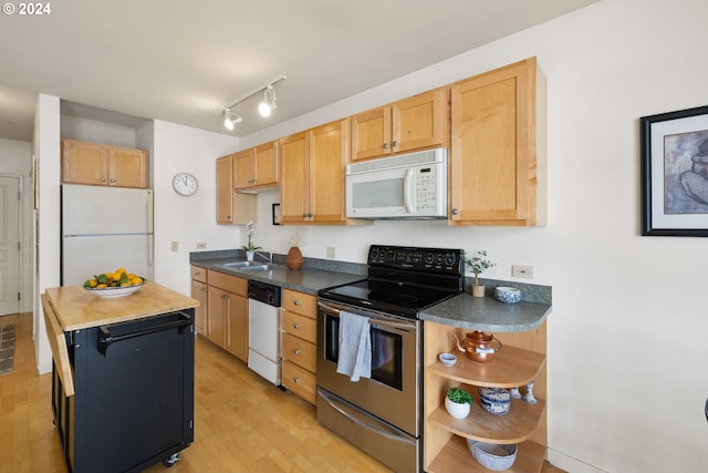 kitchen featuring sink, light brown cabinetry, light hardwood / wood-style flooring, and appliances with stainless steel finishes