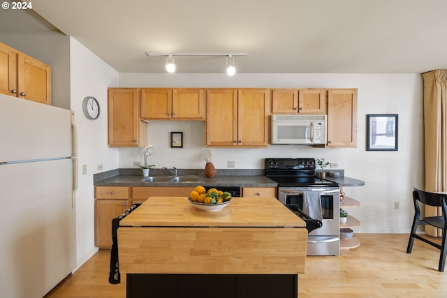 kitchen featuring white appliances, light hardwood / wood-style floors, and sink