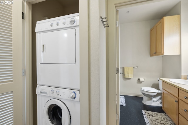 laundry area with sink and stacked washing maching and dryer