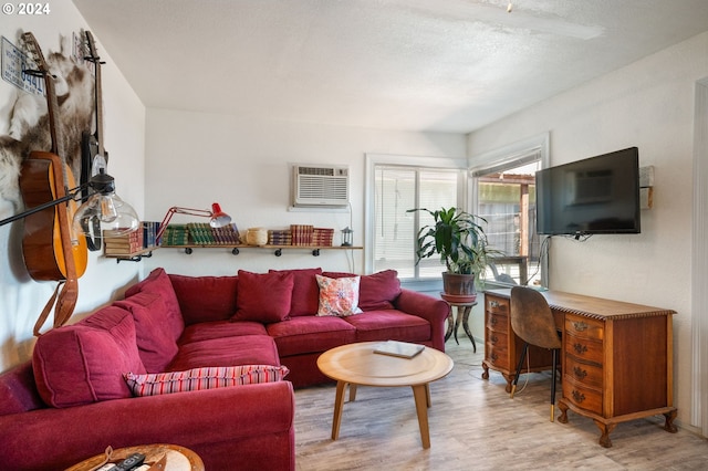 living room featuring light wood-type flooring and a wall unit AC