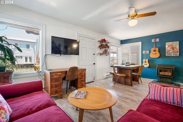 living room with wood-type flooring, baseboard heating, and ceiling fan