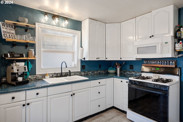 kitchen with white cabinetry, sink, light hardwood / wood-style floors, and white appliances