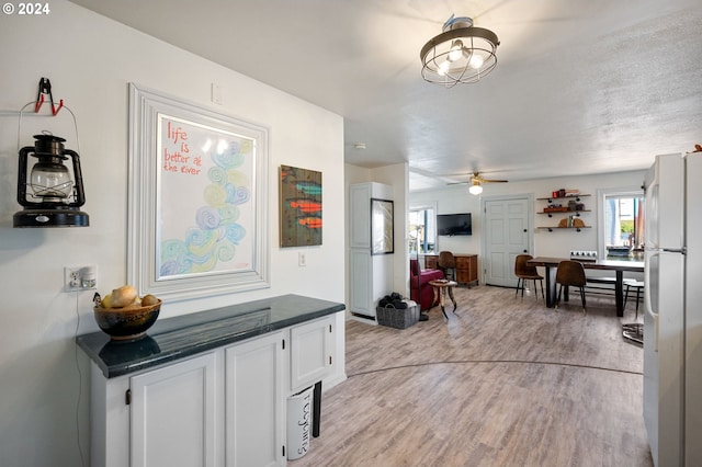 hall featuring light hardwood / wood-style flooring and a textured ceiling