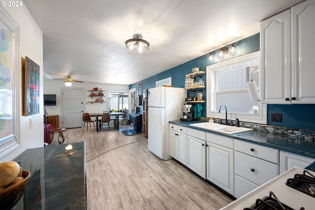 kitchen with white cabinets, sink, ceiling fan, light hardwood / wood-style floors, and white fridge